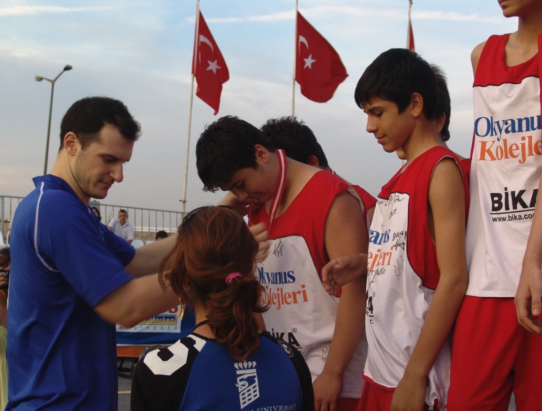 Basketbol etkinliğinin ödül töreninde genç sporculara madalyalarının takılması