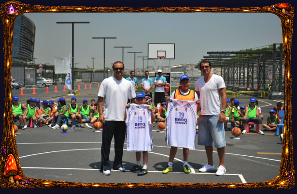 Açık basketbol sahasında çocuklarla birlikte forma tutan iki yetişkin