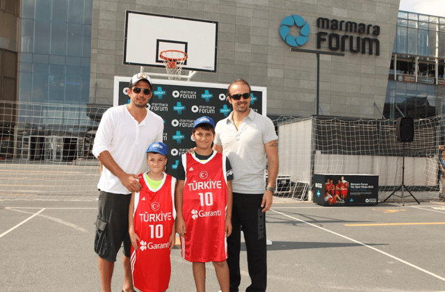 Marmara Forum önündeki basketbol sahasında iki yetişkin ve Türkiye formalı iki çocuğun hatıra fotoğrafı